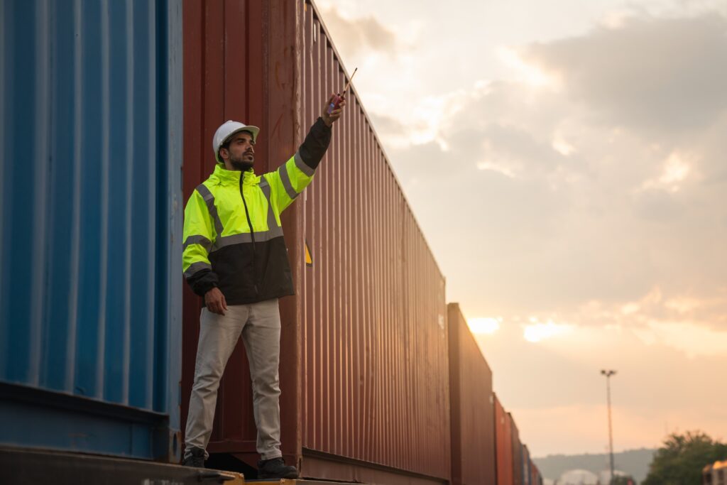 Foreman checking freight train and container inventory for logistics, import, and export.